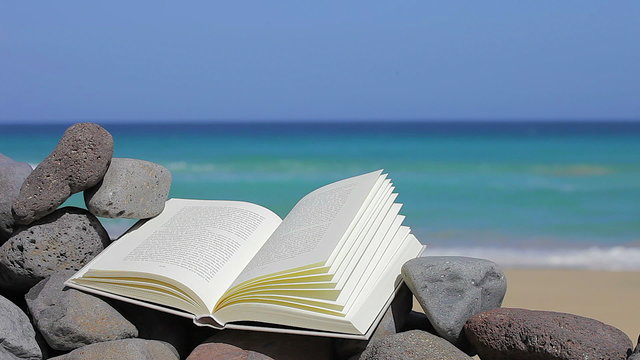 book on the beach with sea on background