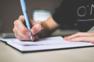 a person holding a pen in hand