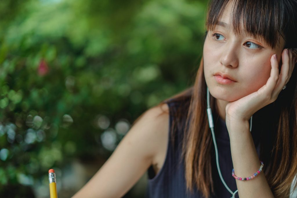 a girl is thinking while writing