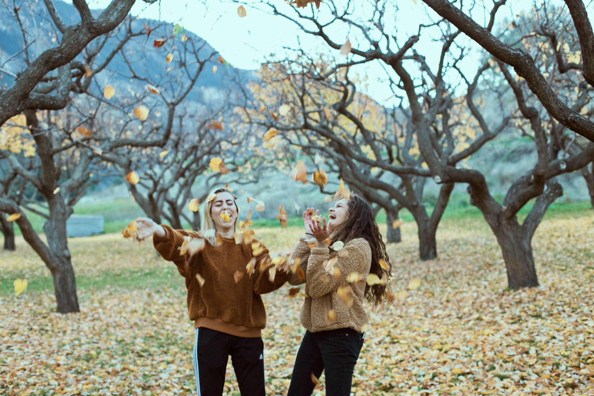 two girls with fallen leaves